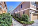 Exterior view of a townhome with lush landscaping and a well-maintained walkway at 5704 Kingletsound Pl, Lithia, FL 33547