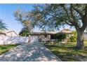 Inviting single-Gathering home featuring an attached garage, lovely landscaping, and a classic white picket fence at 6315 25Th N Ave, St Petersburg, FL 33710