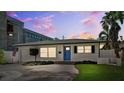 Inviting home exterior with a well-kept lawn, lovely landscaping, and a striking blue front door at 735 Snell Isle Ne Blvd, St Petersburg, FL 33704