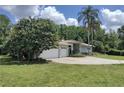 Well-maintained home with a lush lawn and ample driveway space, enhanced by mature trees at 8946 Old Pasco Rd, Wesley Chapel, FL 33544