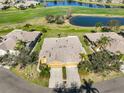 Aerial view of a home with a pond, golf course and lush landscape at 1154 Jameson Greens N Dr # 20, Sun City Center, FL 33573