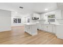 Modern kitchen featuring an island, white cabinetry, stainless appliances, and lots of natural light at 1212 E Crawford St, Tampa, FL 33604