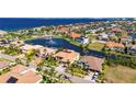 Aerial view of a lovely waterfront home with a pool, spa, screened-in lanai, and lush landscaping at 1335 Jumana Loop, Apollo Beach, FL 33572