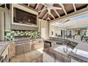 This outdoor kitchen features a built-in grill, sink, TV and plenty of counter space for entertaining at 1335 Jumana Loop, Apollo Beach, FL 33572