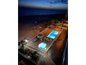 Nighttime view of the pool and hot tub, located directly on the beach at Sea Breeze at 13500 Gulf Blvd # 505, Madeira Beach, FL 33708