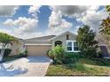 Charming one-story home featuring a two-car garage, a brick paved driveway, and beautifully landscaped yard at 13915 Kingfisher Glen Dr, Lithia, FL 33547