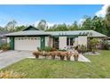 Charming single story home with lush front lawn and colorful flower pots at 15306 Winterwind Dr, Tampa, FL 33624