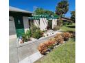 Well-maintained front yard with meticulous landscaping, colorful bromeliads, and a pergola at 15306 Winterwind Dr, Tampa, FL 33624