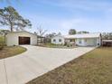 Wide shot of the home featuring the spacious driveway and detached garage/workshop at 15630 Camrose Ave, Spring Hill, FL 34610