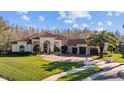 Beautiful Mediterranean-style home with a red tile roof, lush landscaping, and a circular driveway at 5204 Avenue La Crosse, Lutz, FL 33558
