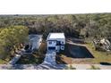 A modern home with clean lines and a patterned driveway sits among lush trees at 7984 Gulf Way, Hudson, FL 34667