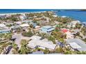 An aerial view shows a community of charming homes near the beach and a tranquil bay at 991 Narcissus Ave, Clearwater Beach, FL 33767