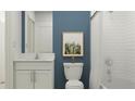 Modern bathroom featuring white subway tile, white vanity, and a stylish blue accent wall at 10212 Gentle Rain Dr, Land O Lakes, FL 34638