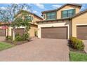 Charming two-story townhome with a brown garage door and a brick driveway at 10800 Tarflower Dr # 202, Venice, FL 34293