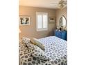 Serene bedroom with a seashell-patterned bedspread, shuttered windows, and a vintage-style blue dresser at 1108 Commodore St, Clearwater, FL 33755