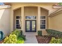 Elegant front entrance with double doors flanked by sidelight windows, showcasing a welcoming and bright entryway at 1213 Halifax Ct, Tarpon Springs, FL 34688