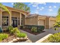 Lovely home featuring a double-door entry, decorative columns, well-maintained landscaping, and an attached garage at 1213 Halifax Ct, Tarpon Springs, FL 34688