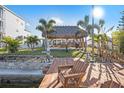 Beautiful waterfront backyard featuring a tiki hut, lush landscaping, and a private dock, perfect for outdoor living at 13429 Lisa Dr, Hudson, FL 34667
