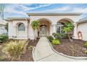Inviting home entrance with arched columns and beautifully landscaped walkway at 13941 Talmage Loop, Hudson, FL 34667