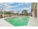 Relaxing screened-in pool area featuring a waterfall, perfect for enjoying the outdoors at 13941 Talmage Loop, Hudson, FL 34667