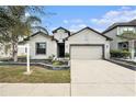 Charming single-Gathering home with a well-manicured lawn and a two-car garage on a sunny day at 14330 Fissore Blvd, Wimauma, FL 33598