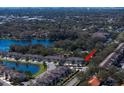 Aerial view of townhomes nestled by a serene lake offering a picturesque community setting. Arrow shows subject home at 1986 Lake Ridge Blvd, Clearwater, FL 33763