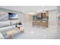 Open-concept living room and kitchen with modern finishes, sleek countertops, and stylish barstool seating at 208 Palmetto W Rd, Nokomis, FL 34275