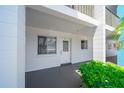 Ground floor condo entrance with white door, painted patio, and green shrubbery at 2113 Canal Dr # B2, Bradenton, FL 34207