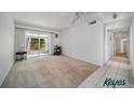 Bright living room with neutral carpet, ceiling fan, and sliding glass doors to enclosed porch at 2113 Canal Dr # B2, Bradenton, FL 34207