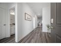 Bright hallway featuring wood-look floors, neutral walls, and access to a bathroom at 35392 Eastbrook Ave, Zephyrhills, FL 33541