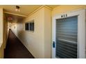 Hallway shot leading to unit 611 with neutral walls, window view, and overhead lighting at 4650 Cove Cir # 611, St Petersburg, FL 33708