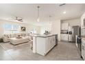 Open-concept kitchen featuring stainless steel appliances and a large island at 5640 Wandering Willow Dr, Wesley Chapel, FL 33545