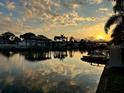 Sunset view over the canal with boat docks and covered slips creating a picturesque and serene waterfront living experience at 8704 Thornwood Ln, Tampa, FL 33615