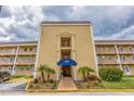 Inviting condo complex exterior showcasing manicured landscaping, a covered entrance, and private balconies at 1 Boca Ciega Point Blvd # 213, St Petersburg, FL 33708