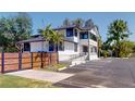 Well-maintained white building with black trim, lush landscaping, a wooden fence, and ample parking space at 10787 Oak Ne St, St Petersburg, FL 33716