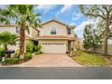 Inviting two-story home boasting a terracotta roof, brick driveway, and mature trees at 1259 Ribolla Dr, Palm Harbor, FL 34683
