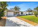 Charming single-story home featuring a well-manicured lawn, a lovely front porch, and an attached garage at 1712 25Th N Ave, St Petersburg, FL 33713