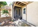 Cozy screened entrance with neutral paint and a white front door, surrounded by lush greenery at 2201 Pine Dr, Tarpon Springs, FL 34689