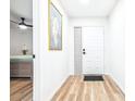 Bright hallway with wood floors, showcasing the front door and a glimpse of the adjacent bedroom at 2201 Pine Dr, Tarpon Springs, FL 34689