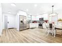 Modern kitchen with stainless steel appliances, white cabinets, and adjacent dining area for easy entertaining at 2201 Pine Dr, Tarpon Springs, FL 34689