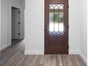 Foyer featuring a stained wood door with decorative glass and wood-look flooring at 23 N Edwards St, Plant City, FL 33563