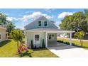 Inviting two-story home featuring lush landscaping, a quaint covered porch, and a freshly paved walkway at 25 W Edwards St, Plant City, FL 33563