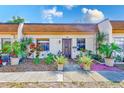 Inviting townhome features a well-manicured lawn and vibrant potted plants near the front door at 2995 Flint S Dr, Clearwater, FL 33759