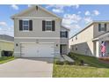 Two-story home showcasing a wide driveway, black shutters, and meticulously maintained landscaping at 4727 Lindever Ln, Palmetto, FL 34221