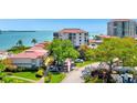 A high-angle shot of a multi-story apartment complex situated near the waterfront, complemented by lush greenery and mature trees at 6268 Palma Del Mar S Blvd # 113, St Petersburg, FL 33715
