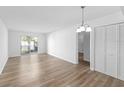 Spacious living area featuring wood-look floors, balcony access, closet, and a modern light fixture at 711 Russell Ln # 238, Brandon, FL 33510