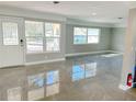 This bright and airy living room features large windows and tile flooring at 9 N Aurora Ave, Clearwater, FL 33765