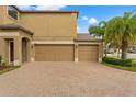 Spacious three-car garage with an elegant brick driveway and manicured landscaping at 9846 Smarty Jones Dr, Ruskin, FL 33573