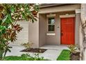 Close-up of a vibrant front door with a smart lock and well-kept landscaping at 10207 Summer Kiss Ave, Riverview, FL 33578