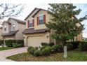 Charming two-story home boasting a two-car garage, red shutters, and mature landscaping at 10262 Newminster Loop, Ruskin, FL 33573